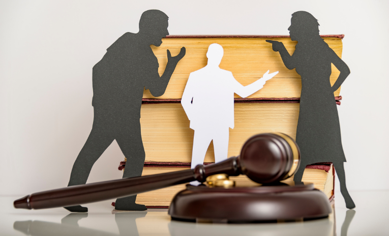 Arbitraje y Mediación: Imagen con una estantería vacía al fondo, un hombre de blanco en el centro, una mujer a la derecha y un hombre a la izquierda discutiendo, con un mazo de juez delante.