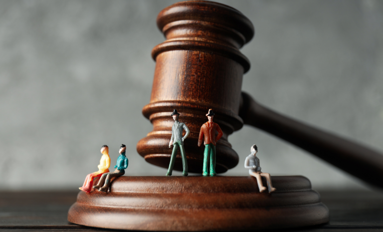 Derecho de la Competencia: Imagen de un mazo de juez con cinco personas en su base.