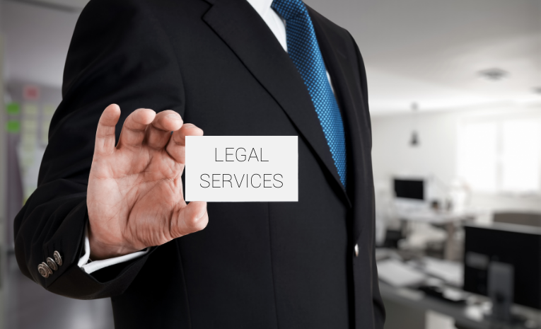 Legal Services: Imagen del torso de un hombre trajeado sosteniendo una tarjeta en blanco que dice 'LEGAL SERVICES'.