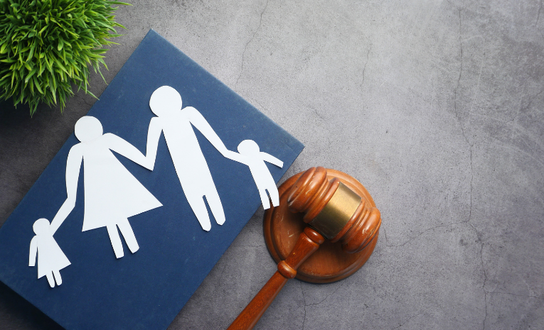 Derecho de Familia: Imagen simbólica con una representación de sol, familia recortada en papel y un mazo de juez.